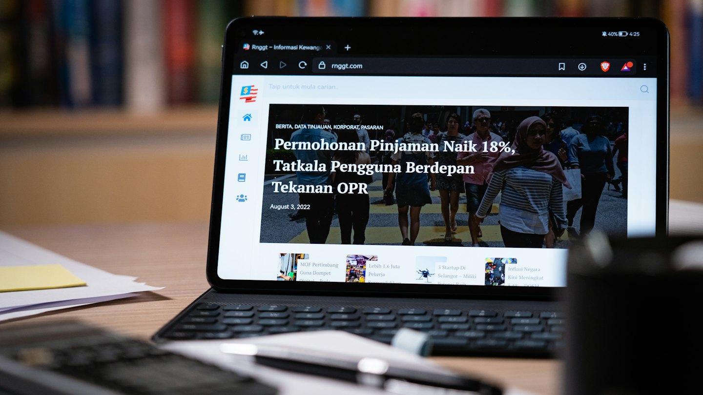 Tablet che mostra notizie finanziarie su una tastiera.